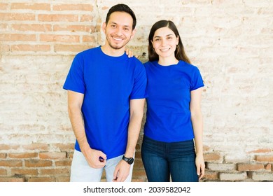 Hispanic young couple with blue matching print t-shirts making eye contact while standing outdoors  - Powered by Shutterstock