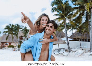 Hispanic young couple in love man and woman having fun on caribbean beach in holidays or vacations in Mexico Latin America - Powered by Shutterstock