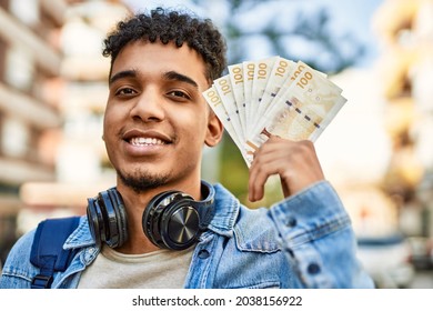 Hispanic Young Man Holding 100 Danish Krone Baknotes At The Street