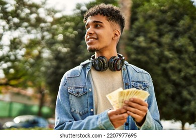 Hispanic Young Man Holding 100 Danish Krone Baknotes At The University Campus