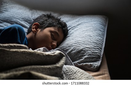 A Hispanic Young Sick Boy Is Sleeping On His Bed With His Head On The Pillow Early In The Morning At His House. Copy Space