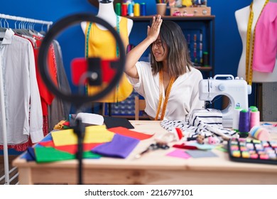 Hispanic Young Tailor Woman Recording Video Tutorial With Smartphone Surprised With Hand On Head For Mistake, Remember Error. Forgot, Bad Memory Concept. 