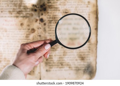  Historian scientist reading antique book with magnifying glass. Translation of religious literature. Manuscript with ancient writings. Treasures of the past. Museum piece - Powered by Shutterstock