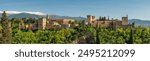 Historic Alhambra palace at sunny day in Granada, Andalusia, Spain. Big panorama shot of the ancient Arabic fortress Alhambra. Granadas famous fortress in spring season