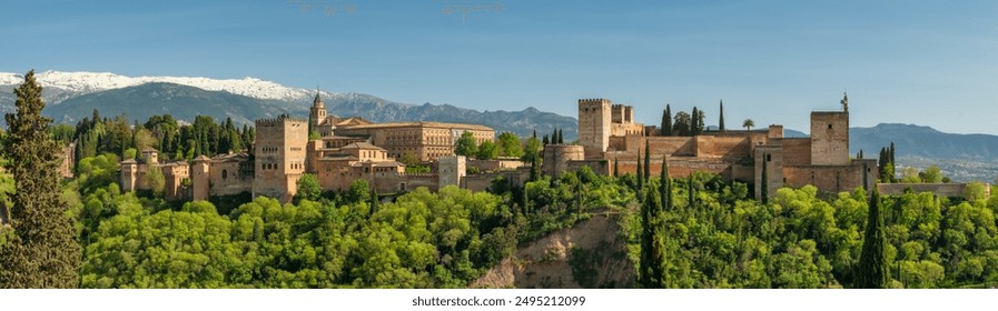 Historic Alhambra palace at sunny day in Granada, Andalusia, Spain. Big panorama shot of the ancient Arabic fortress Alhambra. Granadas famous fortress in spring season - Powered by Shutterstock