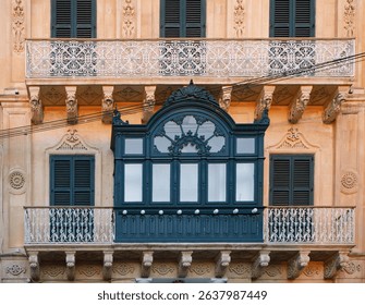Historic Baroque-Style Maltese Balcony and Facade with Ornate Shutters and Ironwork in Valletta at Sunset