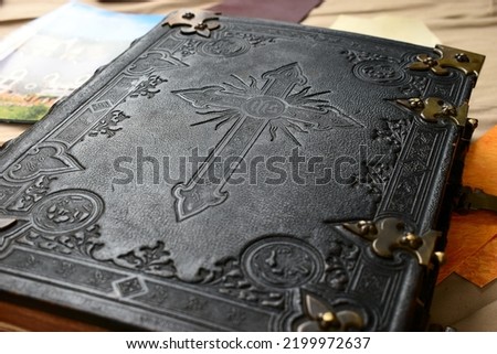 historic bible cover, black leather engraved with religious cross symbol, historic bible