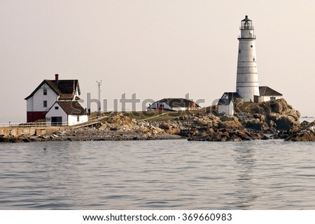 Historic Boston Harbor lighthouse is a popular summertime attraction, especially in the early evening when the sun sets, creating a warm glow.