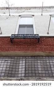 Historic building upper window with iron planter box and glass block panel