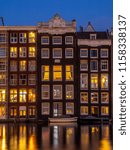 Historic buildings on the Damrak canal in the centre of beautiful Amsterdam at night.