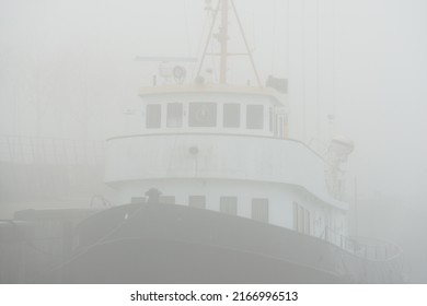 Historic Cargo Boat Moored To A Pier, In A Thick White Morning Fog, Close-up. Kiel, Germany. Transportation, Fishing, Sailing, Logistics, Industry, Traditional Craft, Past, History. Panoramic Image