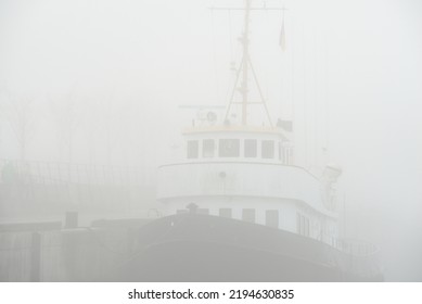 Historic Cargo Boat Moored To A Pier, In A Thick White Morning Fog, Close-up. Kiel, Germany. Transportation, Fishing, Sailing, Logistics, Industry, Traditional Craft, Past, History. Panoramic Image