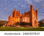 Historic cathedral in city of Newcastle in Australia at sunset with bright lights.