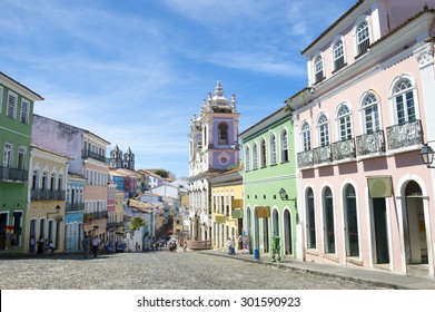 Historic city center of Pelourinho features brightly lit skyline of colonial architecture on a broad cobblestone hill in Salvador, Brazil 