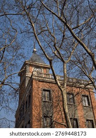 Historic Clock Tower with Bare Trees in Shanghai