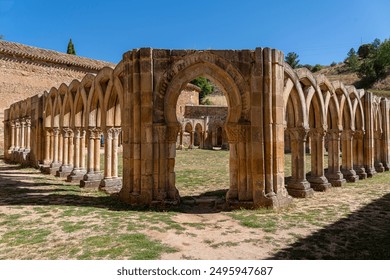 The historic cloister of Monasterio de San Juan de Duero in Soria, Spain, showcasing its iconic arches and ancient stone architecture on a bright sunny day - Powered by Shutterstock