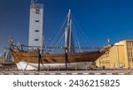 Historic dhow ships timelapse hyperlapse at the Maritime Museum of in Kuwait. Skyscrapers on background with blue sky. Kuwait, Middle East.