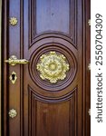 Historic door leaf richly decorated with shiny golden fittings, main portal of the Evangelical Church of St Peter and Paul from 1866 in Gross Lassowitz, Poland.