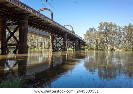 The historic Echuca-moama Road Rail Bridge over the calm waters of the Murray River. It's between the twin towns of Echuca in Victoria and Moama in New South Wales and a heritage local landmark.