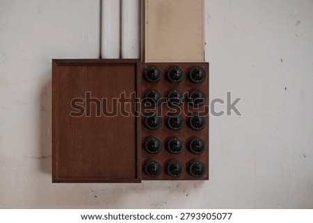 Historic electrical switchboard featuring multiple rotary switches mounted on a wooden control panel. Vintage electrical infrastructure preserved as part of industrial and technological heritage.