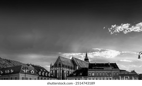 Historic European Cityscape with Dramatic Sky at Sunset. Black and white photo of an old European cityscape featuring historic buildings and a dramatic, cloudy sky at sunset.  - Powered by Shutterstock