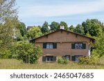 A historic flat-roofed farmhouse from 1740 with a wooden shingle façade