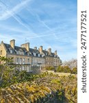 Historic French houses, blue sky and green landscaping