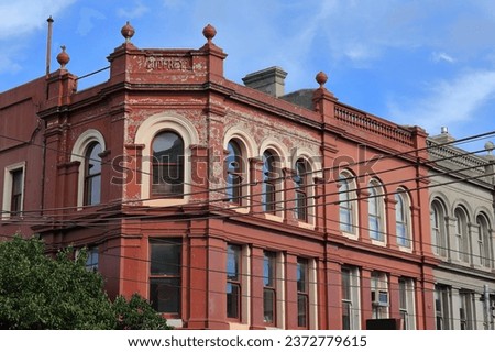 Historic Godfrey 1 building from AD 1887 in High Victorian style of three-storey shops and residences, two street painted rendered brick facade, splayed corner. Fitzroy suburb-Melbourne-VIC-Australia.