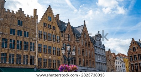 Historic Gothic architecture reflected along a canal in Bruges, Belgium featuring medieval brick buildings and one of the city's most recognizable cultural landmarks