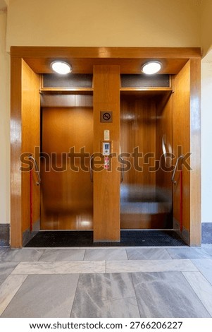 Historic paternoster elevator with continuously moving cabins inside a building. Unique mechanical transport system representing early engineering and vertical circulation technology.