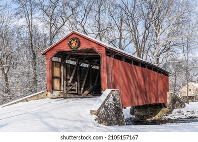 Historic Pool Forge Covered Bridge with snow on a bright winter day in Lancaster County, Pennsylvania, USA