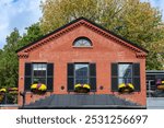 Historic red-brick building with flower-adorned windows and dentil molding in Cambridge, Massachusetts, USA