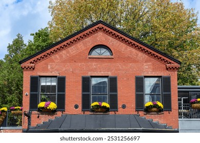 Historic red-brick building with flower-adorned windows and dentil molding in Cambridge, Massachusetts, USA - Powered by Shutterstock