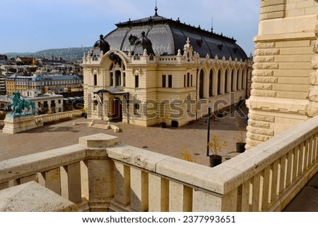 the historic Riding hall building in the castle in Budapest. classic enamel finished clay tile mansard roof. travel and tourism concept. famous attraction and landmark. residential hills background.