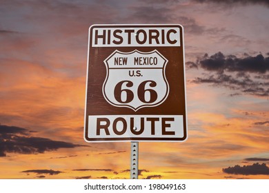 Historic Route 66 New Mexico sign with sunset sky.