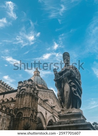 A historic statue in front of the Palermo Cathedral in Sicily, Italy. The stunning architecture, intricate carvings, and domed roof highlight the city's rich cultural and artistic heritage 