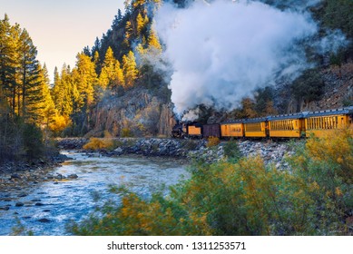 Historic steam engine train travels from Durango to Silverton through the San Juan Mountains along the Animas River in Colorado, USA.