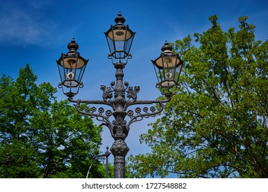 Historic and still functional street lamp that is powered by gas and stands in a Berlin park.