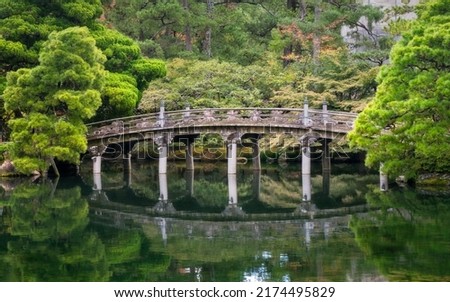 Historic stone bridge at Gonaitei garden on beautiful autumn day in Kyoto Imperial palace in Kyoto, Japan. Oike-niwa - serene japanese zen garden and pond