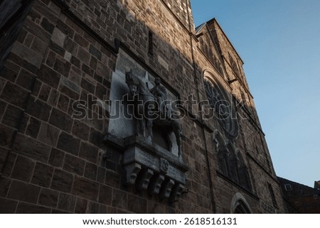 A historic stone cathedral wall featuring an equestrian statue of a knight or noble figure embedded in a prominent niche on the facade of Church of Our Lady.
