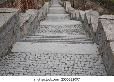 A historic stone staircase featuring cobblestone steps and sturdy stone railings, blending classic architecture with rustic charm. Ideal for outdoor, heritage, and architectural-themed projects. - Powered by Shutterstock