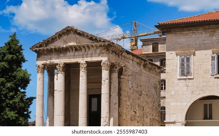 A historic temple facade with classical columns captured against a bright blue sky. The ancient architecture blends with modern construction elements, showcasing a juxtaposition of old and new. - Powered by Shutterstock