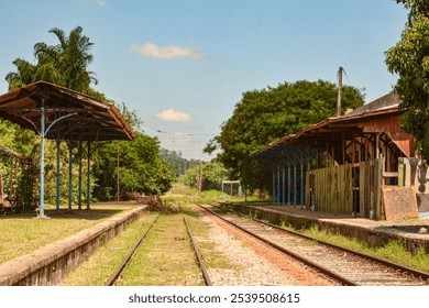 A historic train station with vintage architecture, featuring an empty platform and rustic benches. The setting evokes nostalgia, with soft lighting adding warmth to the scene. - Powered by Shutterstock