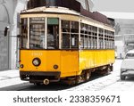 Historic tram or streetcar in the city centre of Milan in Italy. Single old timer car for public transport passing the cathedral and opera in midtown. Blurred black and white vintage background. 