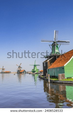 Historic windmills reflected in the water of the Zaan river in Zaanse Schans, Netherlands