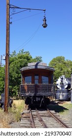 Historic Wooden Passenger Car Beneath An Antique Wrought Iron Light Fixture