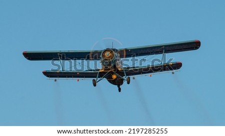 Historical biplane flying. Single engine aircraft designed in 1947. Old utility plane used in forestry and agriculture for crop-spraying.