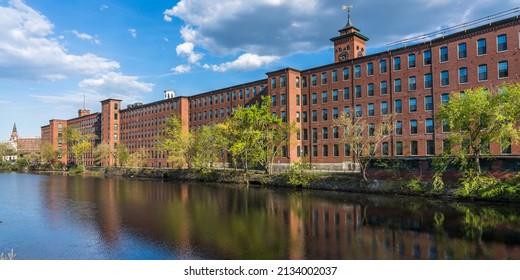 Historical Building Of A Cotton Factory With A Clock Tower In An Old Industrial Park  On Nashua River In May. Nashua, New Hampshire, USA