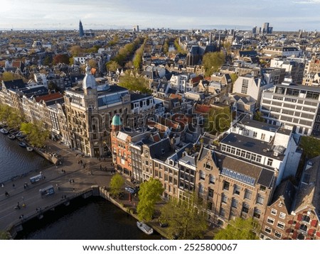 Historical Center of Amsterdam, Netherlands. Aerial Drone Shot of Traditional Dutch houses on narrow street and channel.