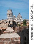 historical landmark leaning tower of Pisa in Tuscany Italy campanile bell tower of cathedral. Unusual view of iconic tourist attraction and photo opportunity with no people. sunny blue sky summer day